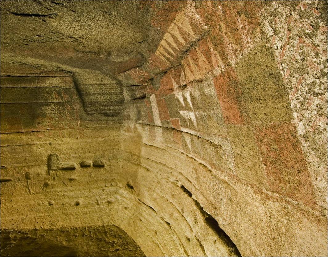 Pinturas geométricas rojas, blancas y negras en la pared de la Cueva Pintada