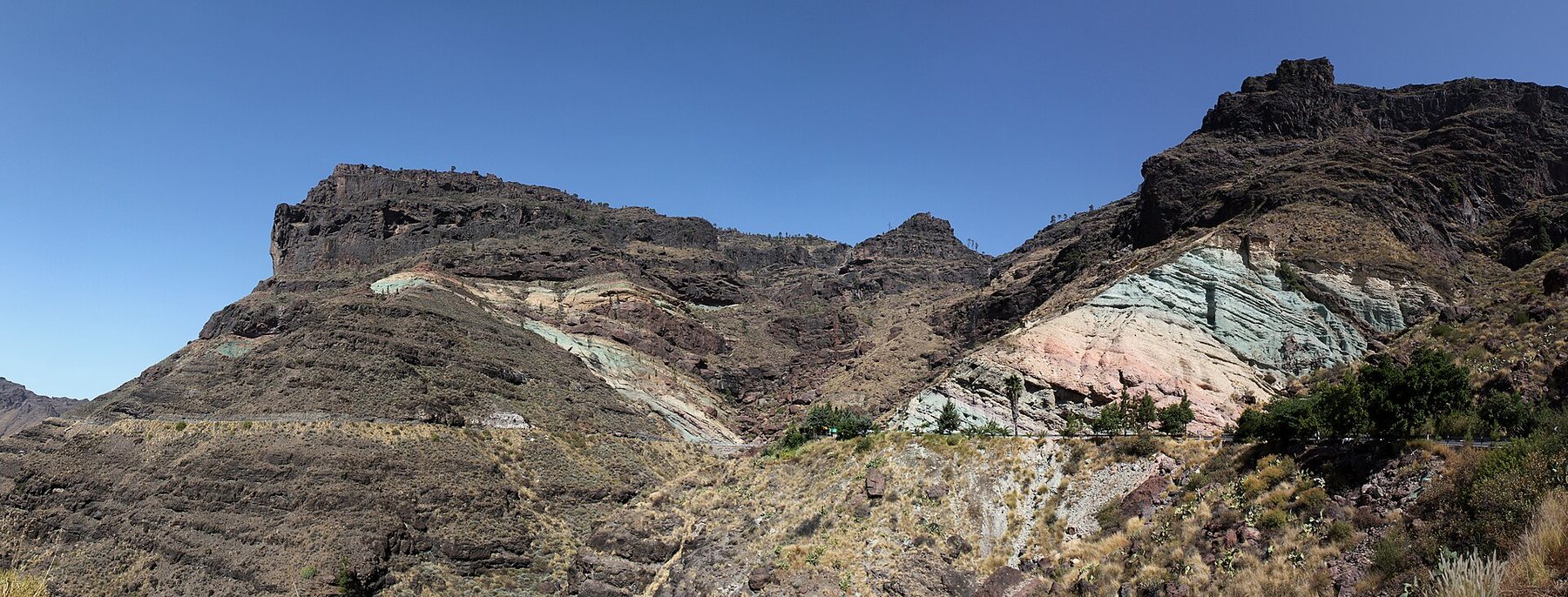Ladera de colores verdes, ocres y rosados en Los Azulejos de Veneguera