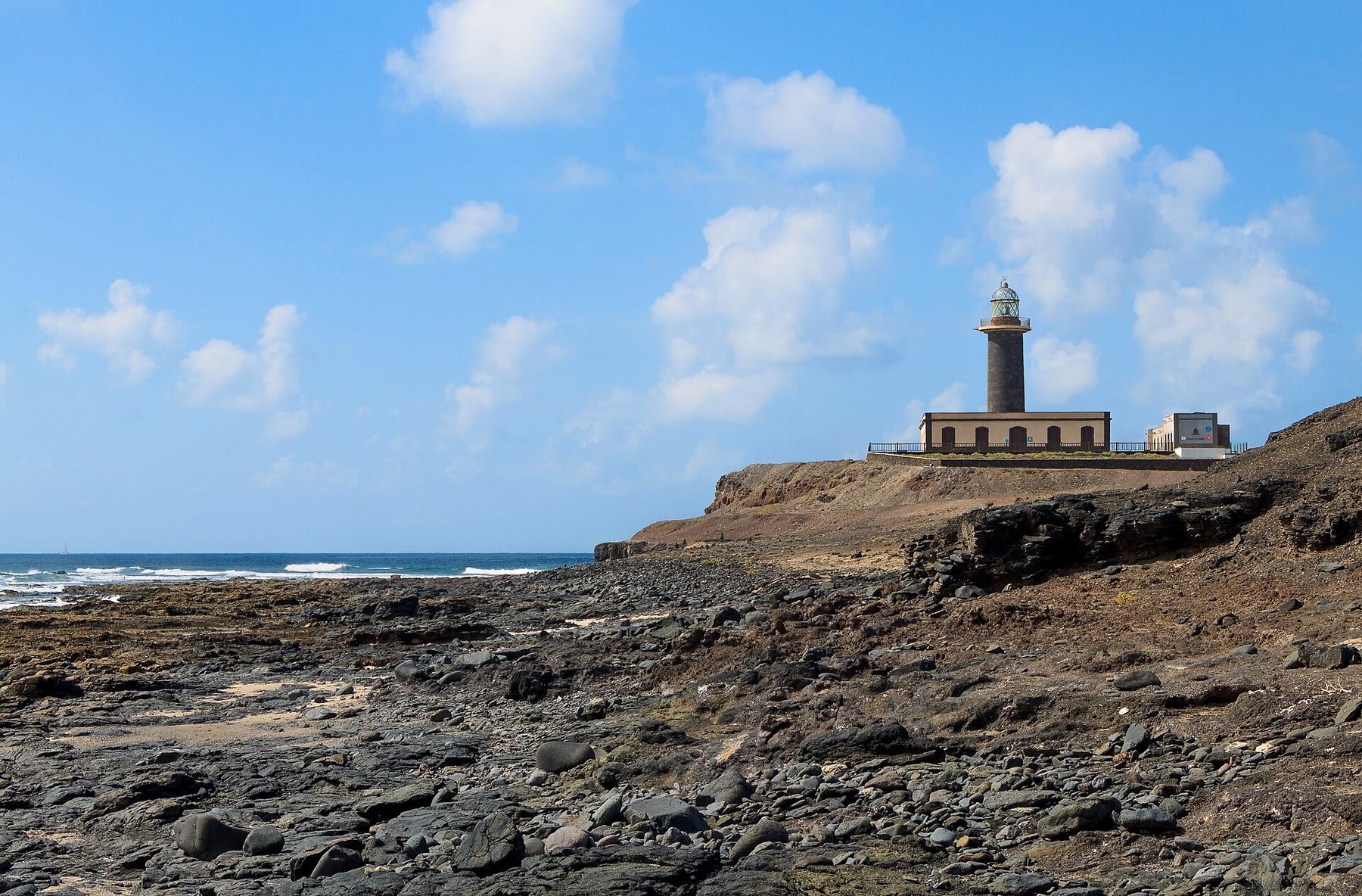 Faro de Punta de Jandía sobre un acantilado de lava, con el Atlántico al fondo